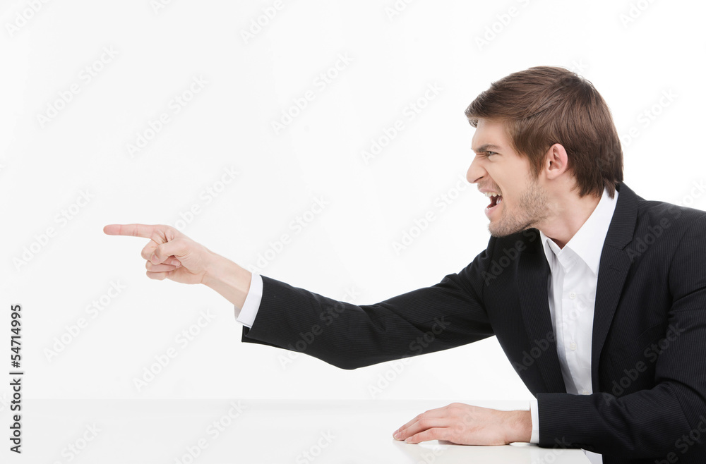 Aggressive businessman. Side view of angry young businessman sho Aggressive businessman. Side view of angry young businessman sho