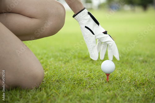 Hand lady placing golf ball on tee