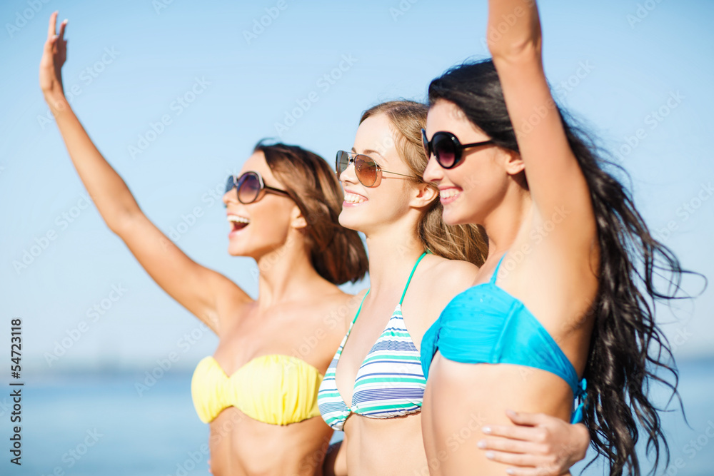 girls in bikini walking on the beach