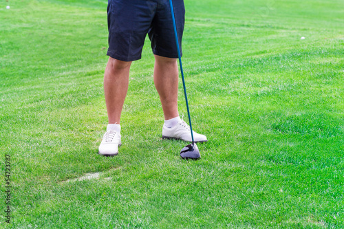 Low section of golf player ready to hit the ball