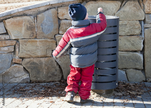 Child at rubbish or garbage bin