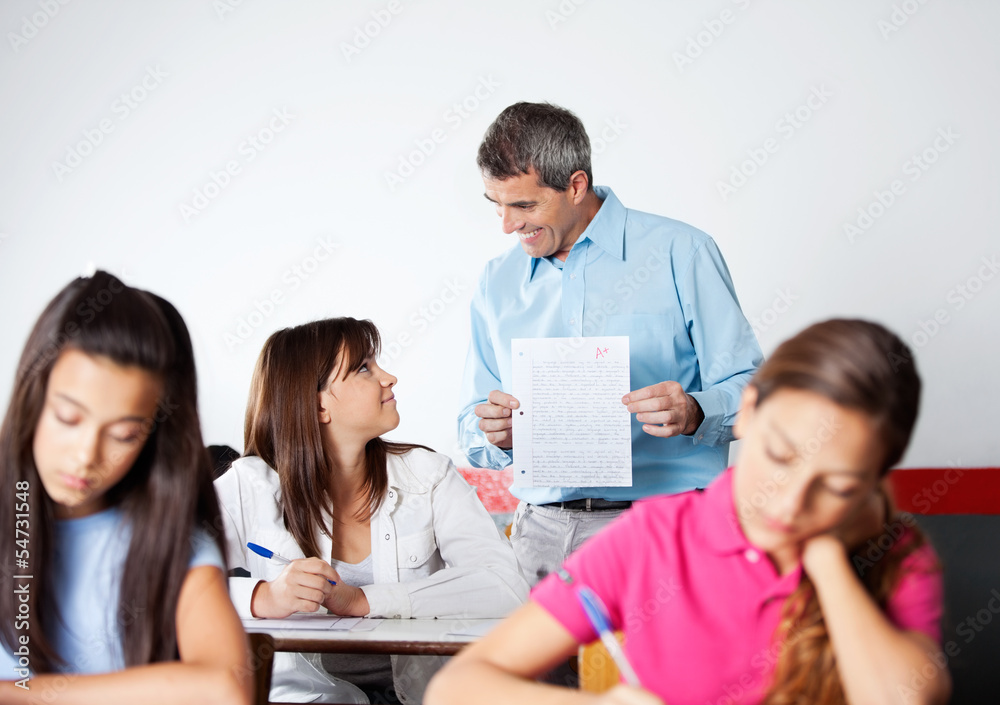 Male Professor Showing Paper To Student During Examination Male Professor Showing Paper To Student During Examination