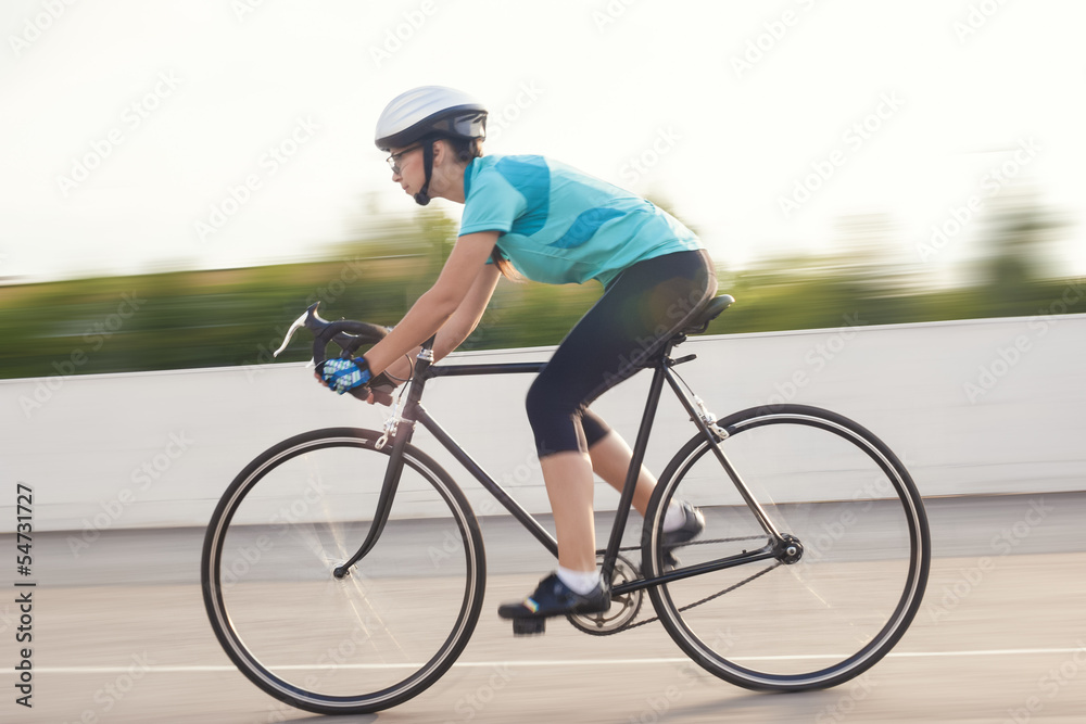 portrait of young female athlete racing on a bike. motion blurre portrait of young female athlete racing on a bike. motion blurre