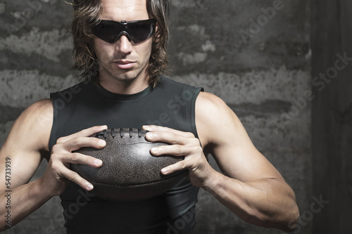 football player is  holding ball in hands photo