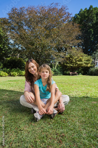 Cheerful mother and daughter on the grass