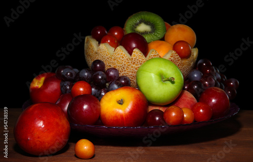 Fototapeta Naklejka Na Ścianę i Meble -  Assortment of juicy fruits on wooden table, on  dark background