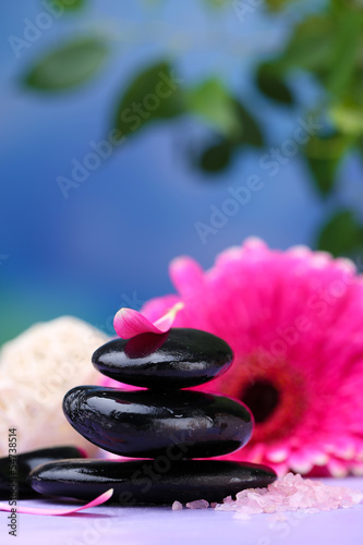 Spa stones and beautiful gerbera on wooden table