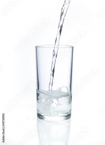 Fresh water pouring in a glass on white background.