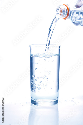 Fresh water pouring in a glass on white background.