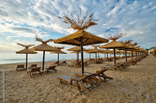 beach with wooden sunshades in the morning