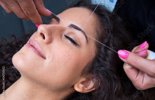 woman on facial hair removal threading procedure