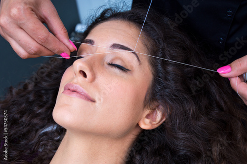 woman on facial hair removal threading procedure