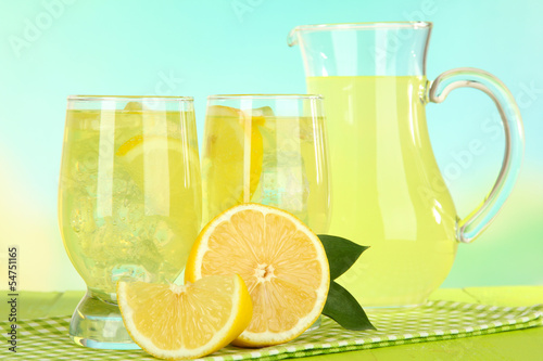 Delicious lemonade on table on light blue background