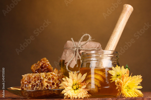 two jars of honey,honeycombs and wooden drizzler photo