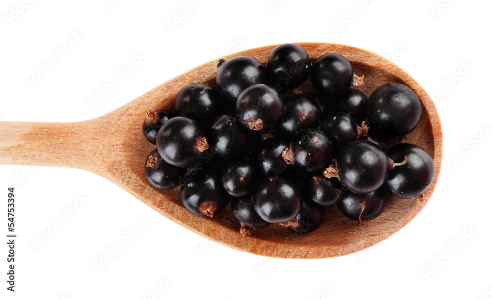 Black currant in wooden spoon isolated on white