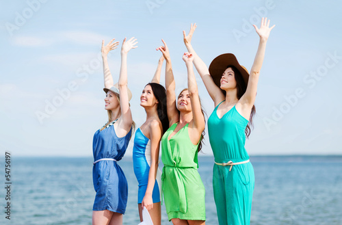 girls looking at the sea with hands up