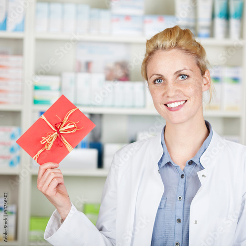 lächelnde apothekerin mit gutschein photo