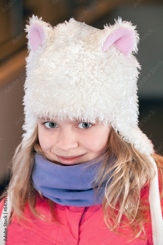 Little blond girl in fun white artificial fur hat Little blond girl in fun white artificial fur hat