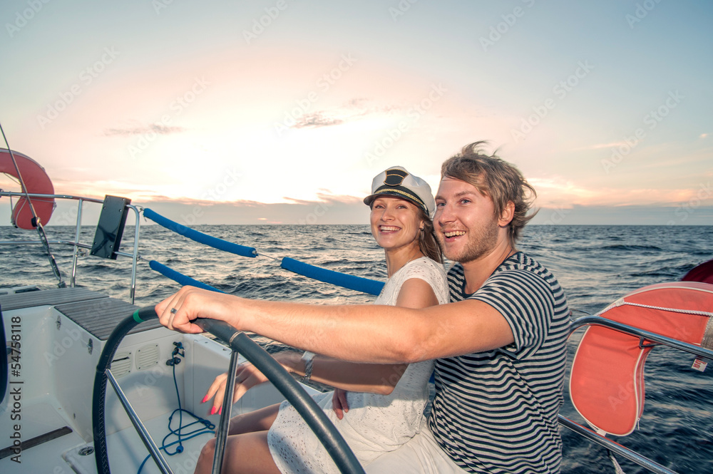 Young couple navigating on a yacht