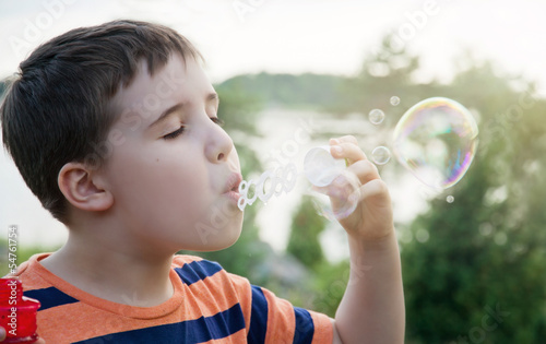 Young boy blowing soap bubbles