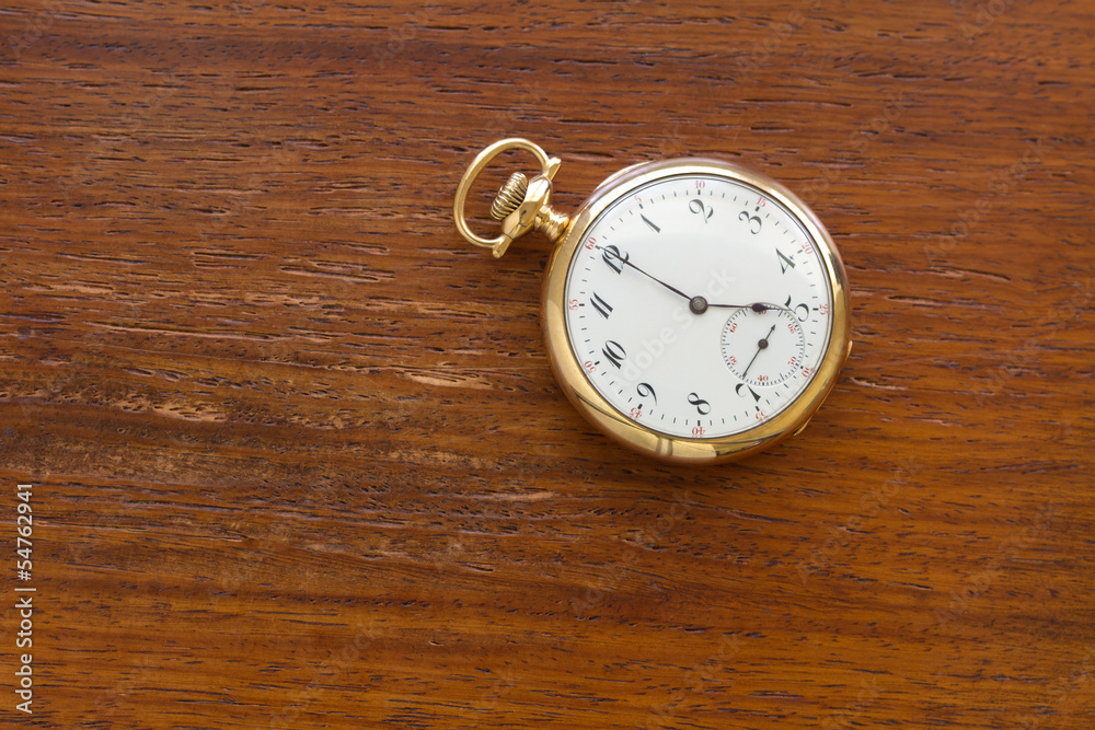 Gold Pocket watch on wood background