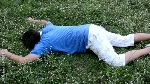An Asian guy is drop dead on the grassy ground and twitching