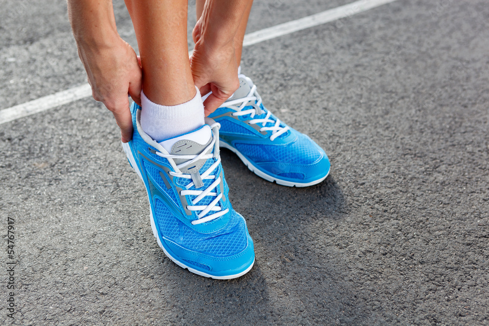 Closeup of Young Woman Tying Sports Shoe