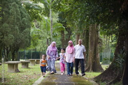 malay muslim family having fun in the park