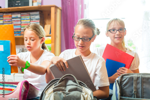 Mädchen packen Ranzen für Schule photo