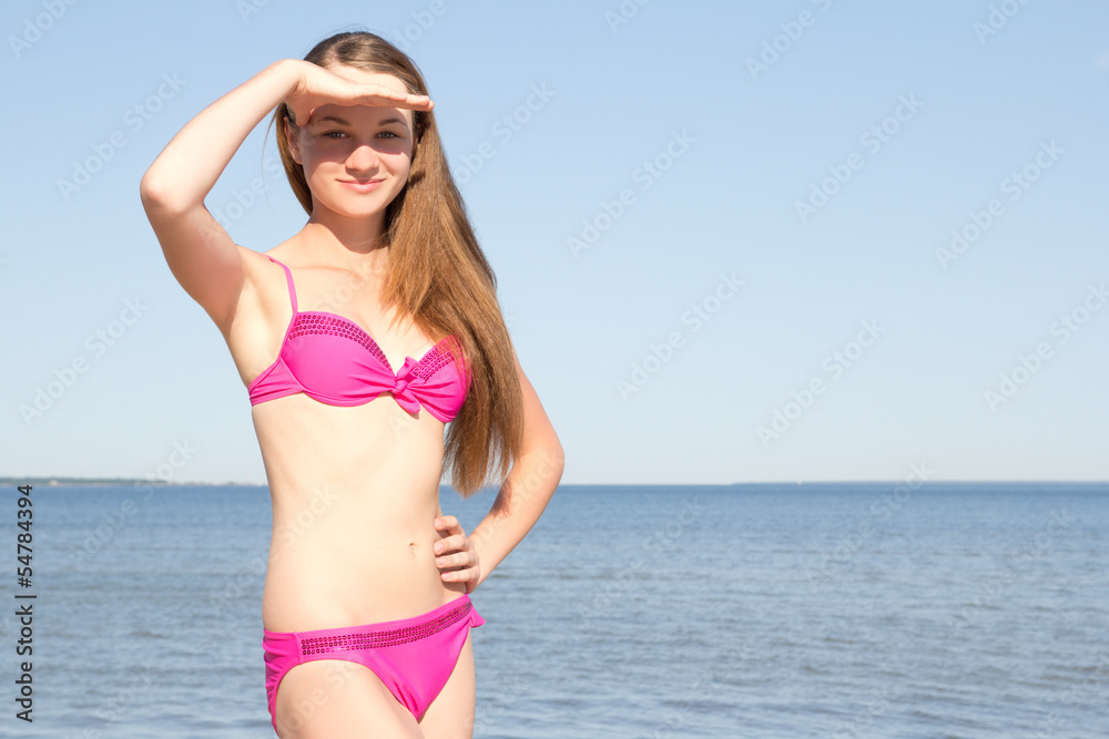 attractive woman in pink bikini posing on the beach