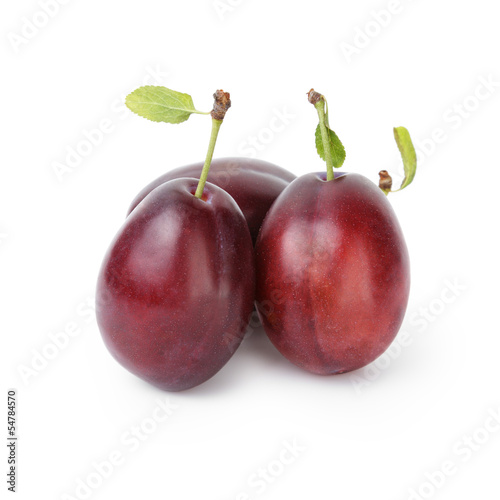 three ripe plums with leaves