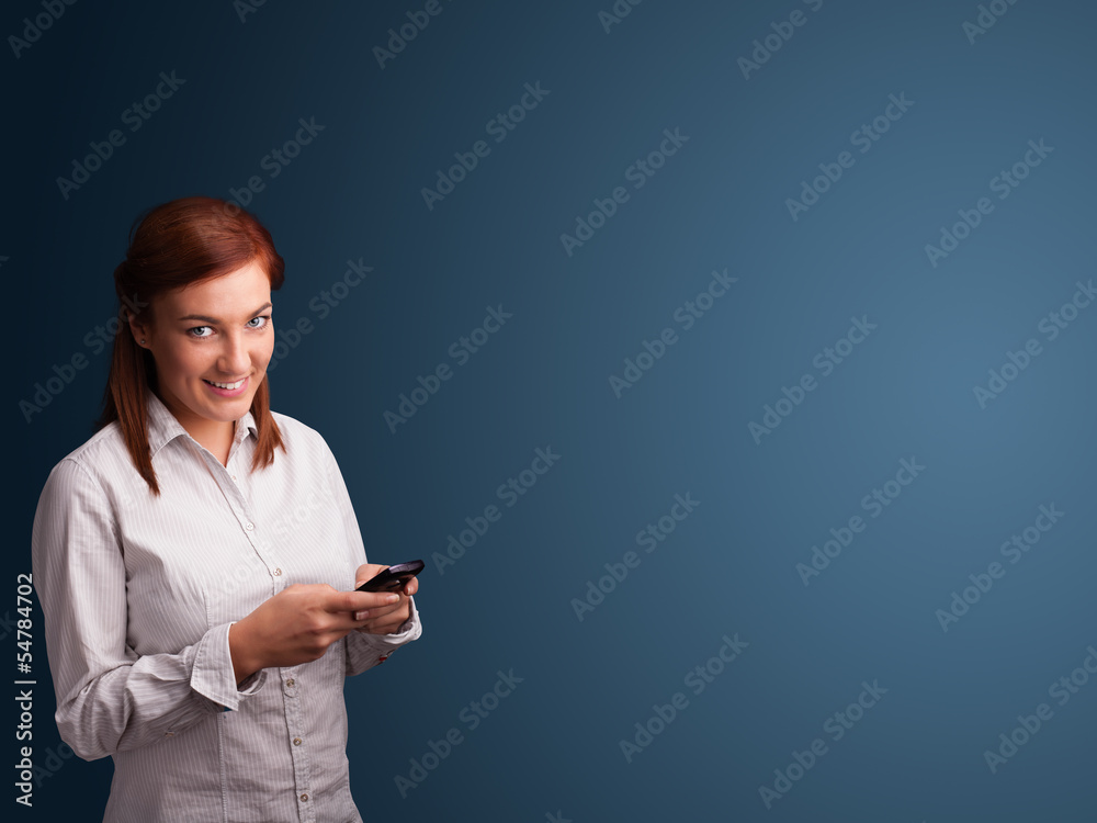 Young woman standing and typing on her phone with copy space Young woman standing and typing on her phone with copy space