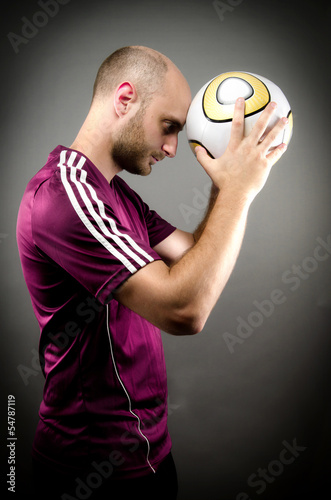Soccer Player Holding Ball against Head