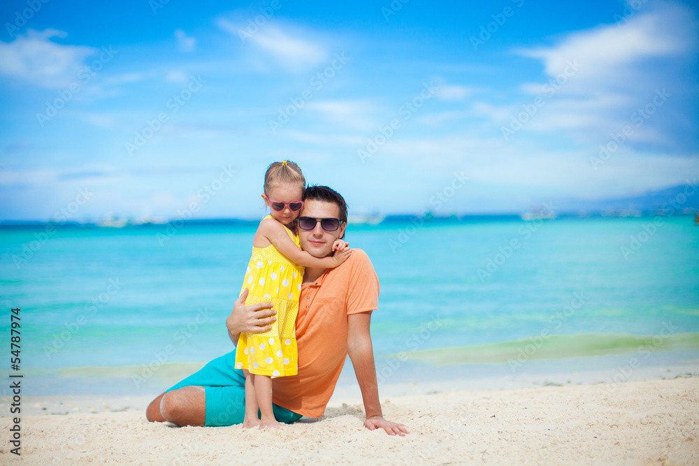 Young father and his adorable little daughter have fun at beach
