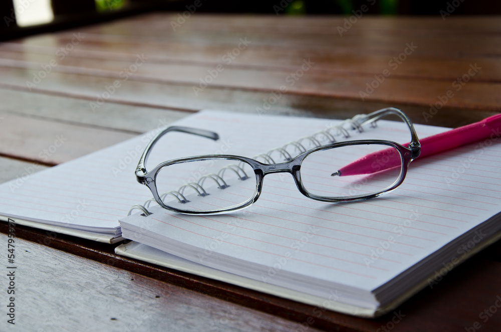 eye glasses on notebook on table eye glasses on notebook on table