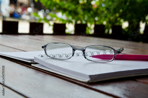 eye glasses on notebook on table
