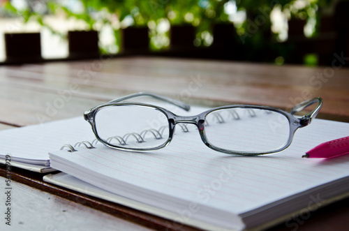 eye glasses on notebook on table