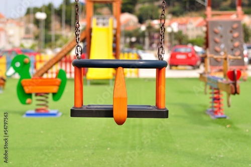 Empty chain swing on modern colorful children playground