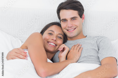 Woman embracing her boyfriend in bed