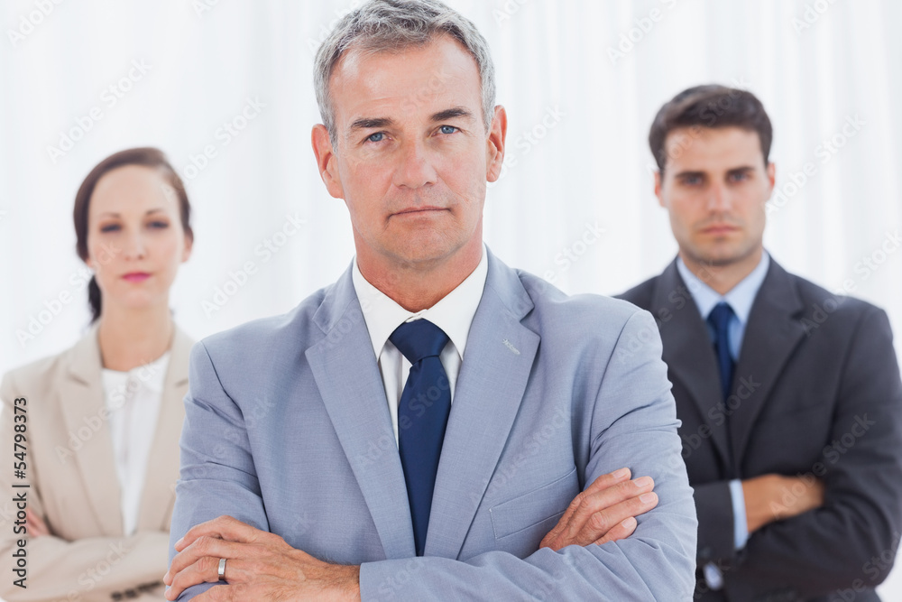 Serious businessman posing with his work team Serious businessman posing with his work team