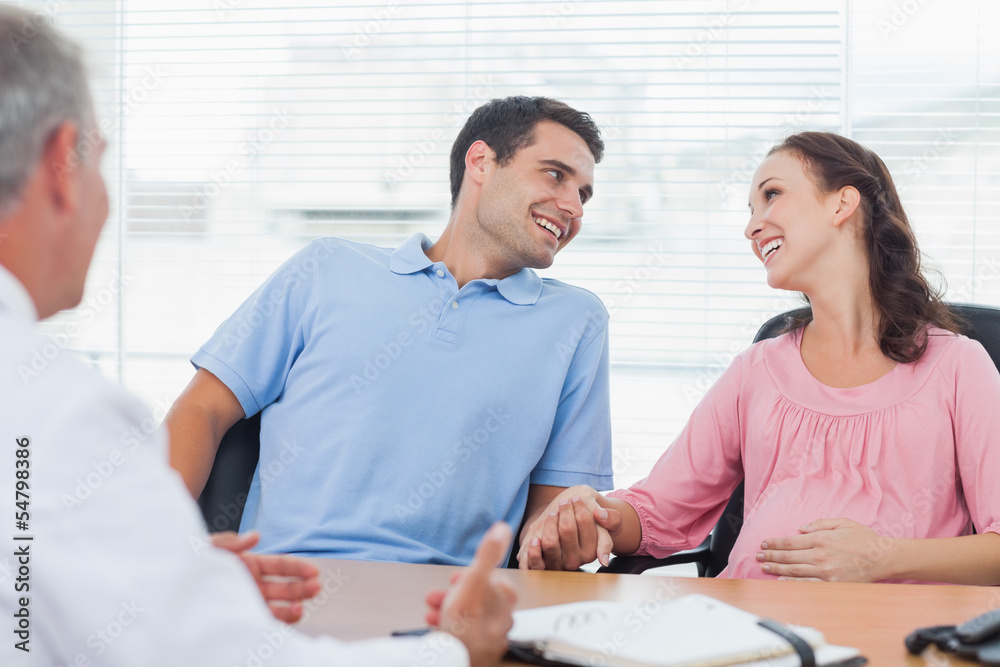 Loving couple expecting baby consulting doctor Loving couple expecting baby consulting doctor