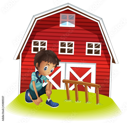 A sad boy in front of the barnhouse