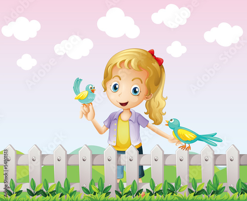 A girl with two birds near the wooden fence