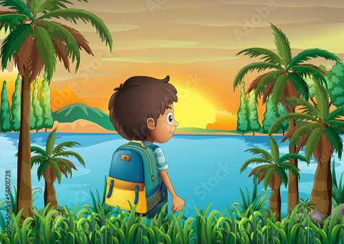 A boy with a bag watching the sunset