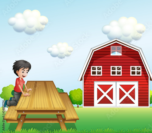 A boy at the table near the barnhouse