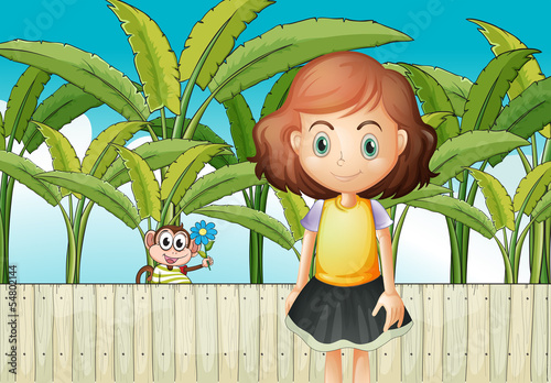 A young girl and a monkey near the fence