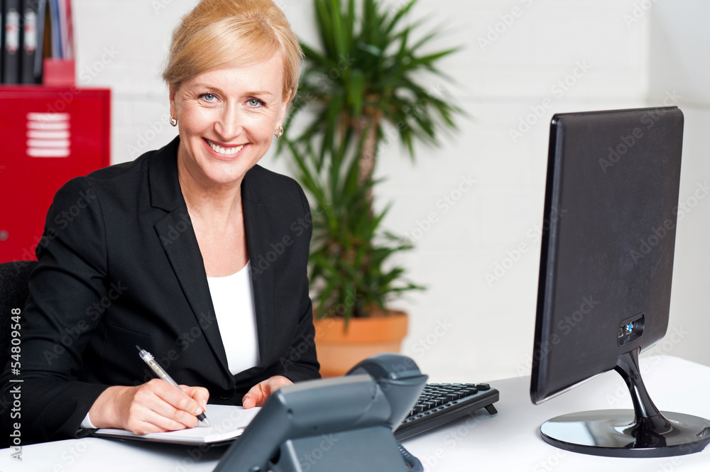 Business executive writing her appointments Business executive writing her appointments