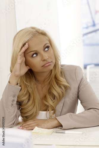 Attractive businesswoman daydreaming at desk