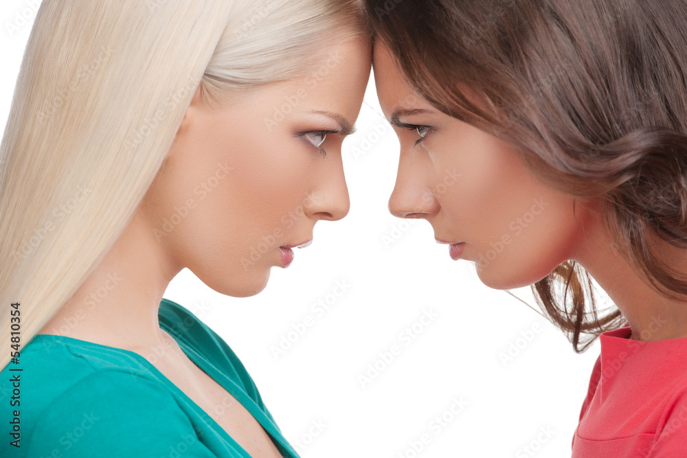 Confrontation. Two angry women standing face to face with their Confrontation. Two angry women standing face to face with their
