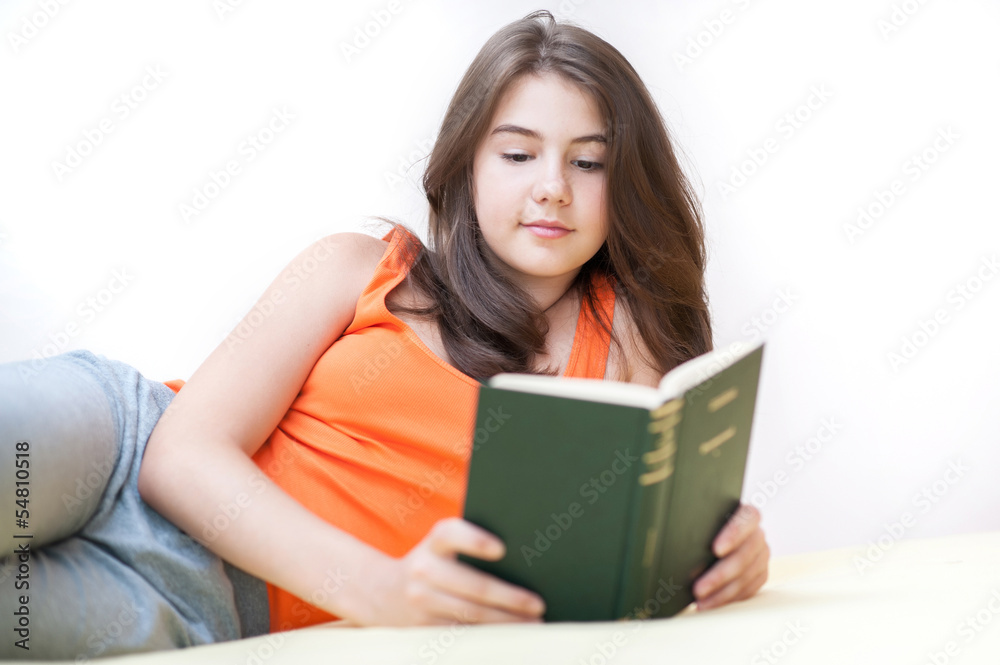 Teenage girl lying and reading a book Teenage girl lying and reading a book